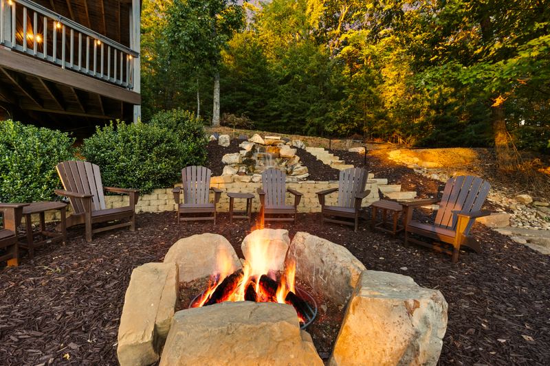 The fire pit lit, ringed by Adirondack chairs