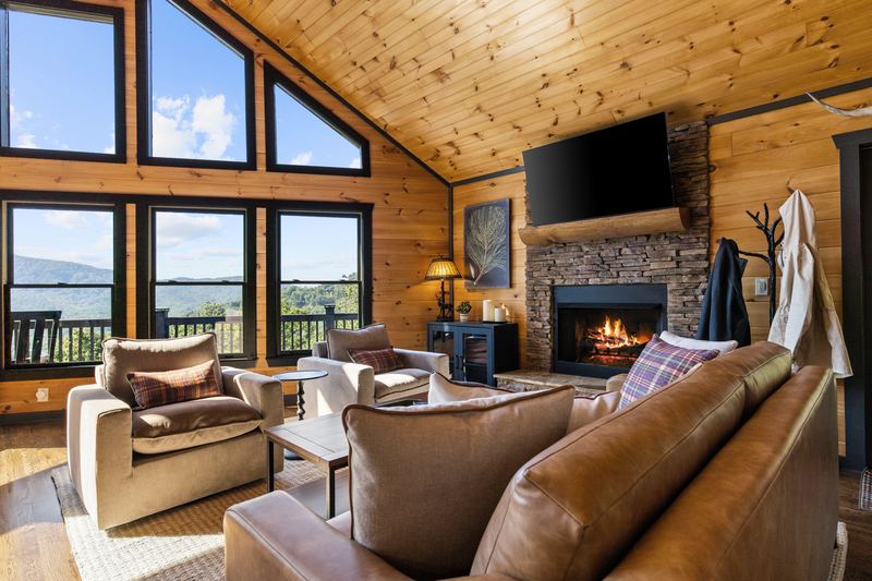 Leather sofa and armchairs facing the stone fireplace
