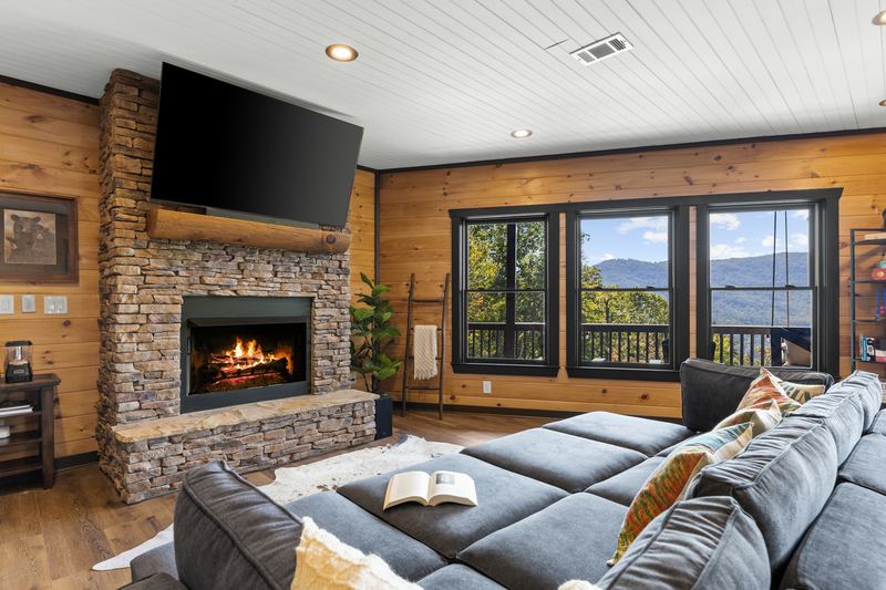 The lower living room's sectional and stone gas fireplace
